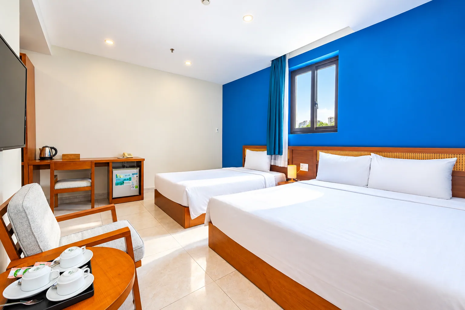 Deluxe Family room with two beds and a blue accent wall at Nam Chau Stellar