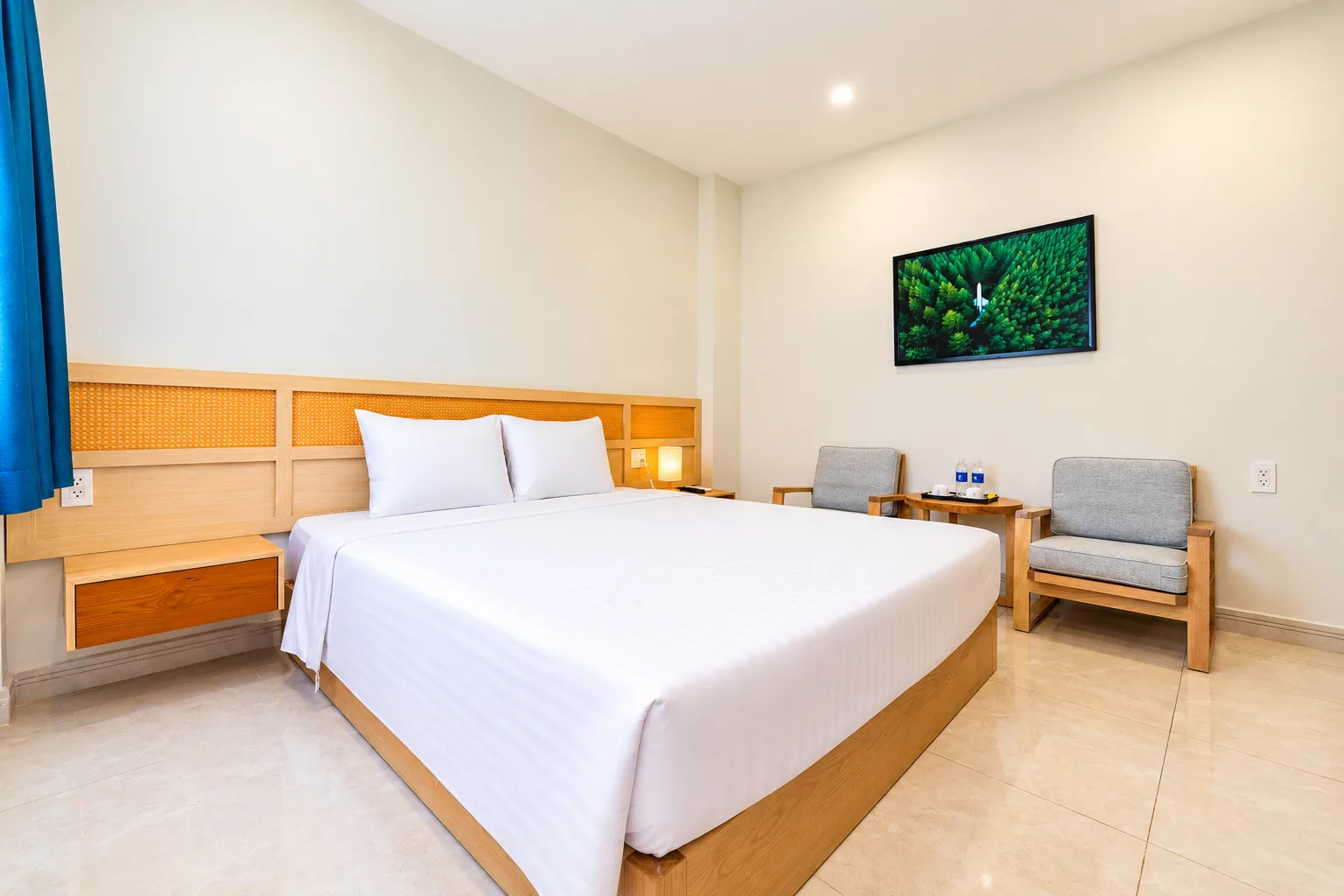 Deluxe room with a bed, wood furnishings and a seating corner at Nam Chau Stellar